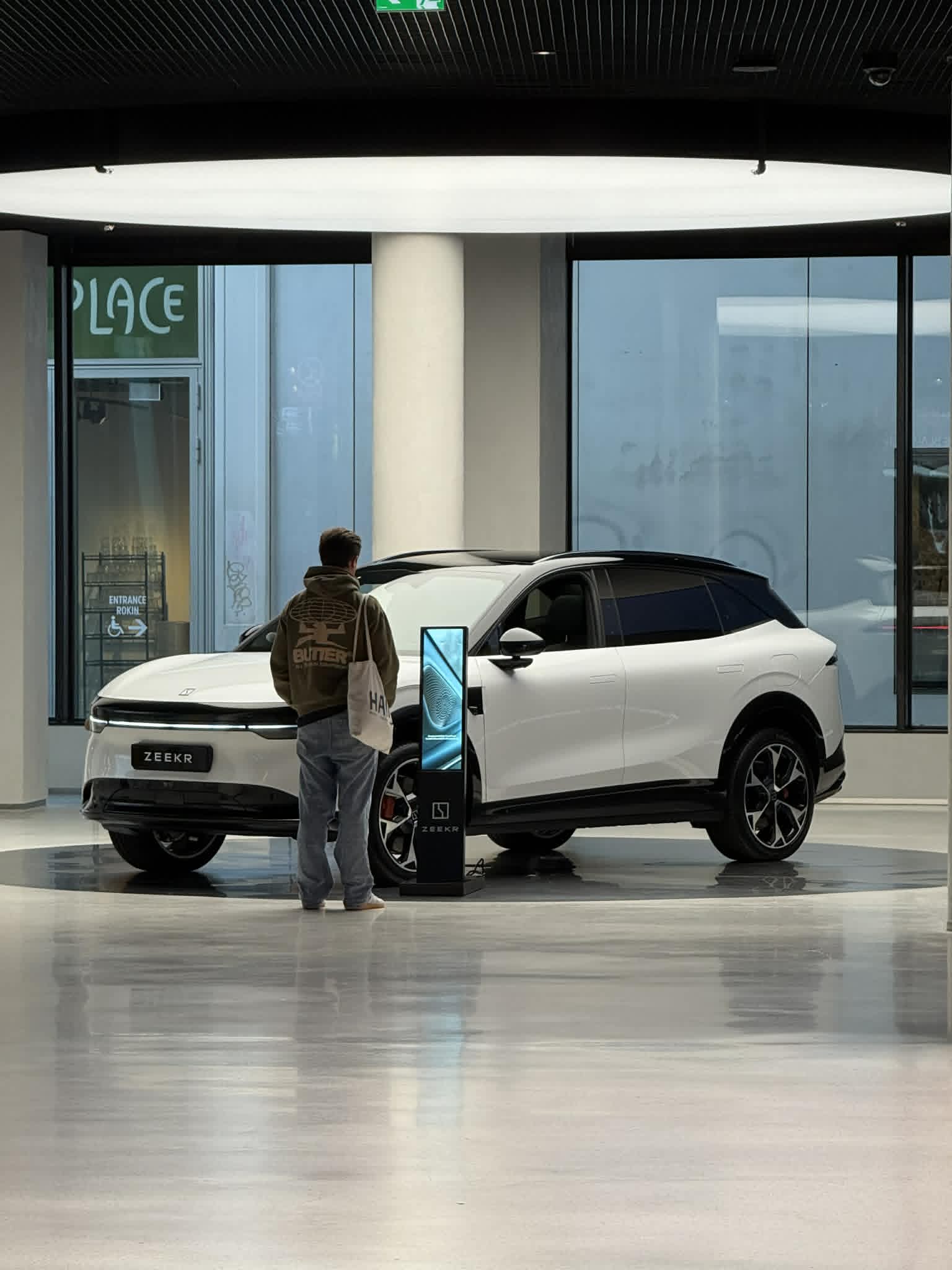 Zeekr showroom — visitor interacting with LED totem